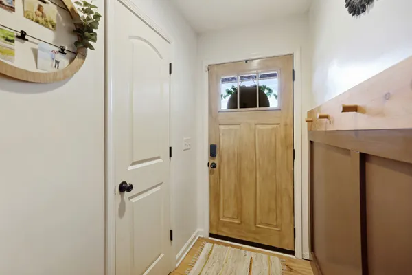 a view of a hallway with wooden floor and a living room