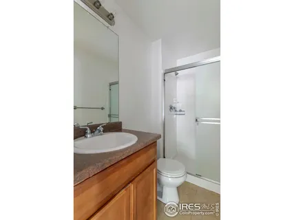 a bathroom with a granite countertop sink toilet a mirror and shower