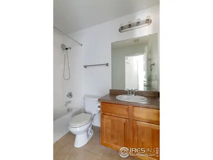 a bathroom with a granite countertop toilet sink and mirror