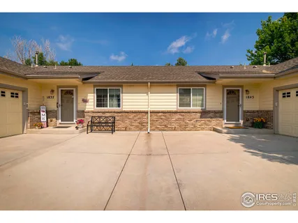 a view of a house with a yard and potted plants