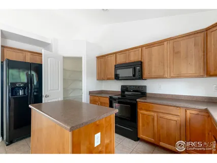 a kitchen with a sink a microwave a refrigerator and cabinets