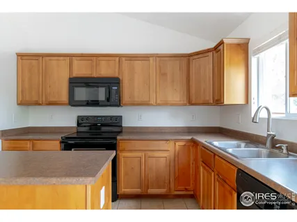 a kitchen with stainless steel appliances a stove a sink a microwave a refrigerator and cabinets