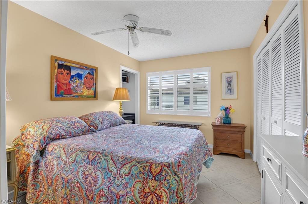 572 High Point Drive, Unit D Delray Beach, FL 33445 - Photo 11 of 21 a bedroom with a bed and a chandelier