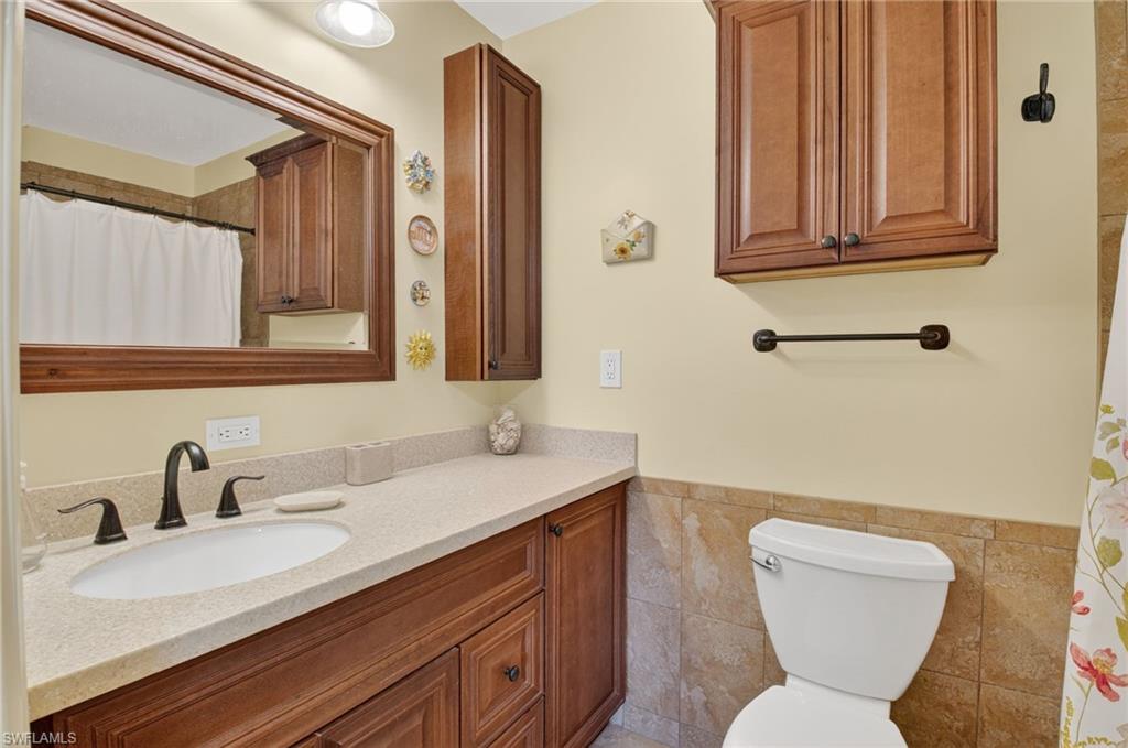 572 High Point Drive, Unit D Delray Beach, FL 33445 - Photo 12 of 21 a bathroom with a toilet sink and mirror