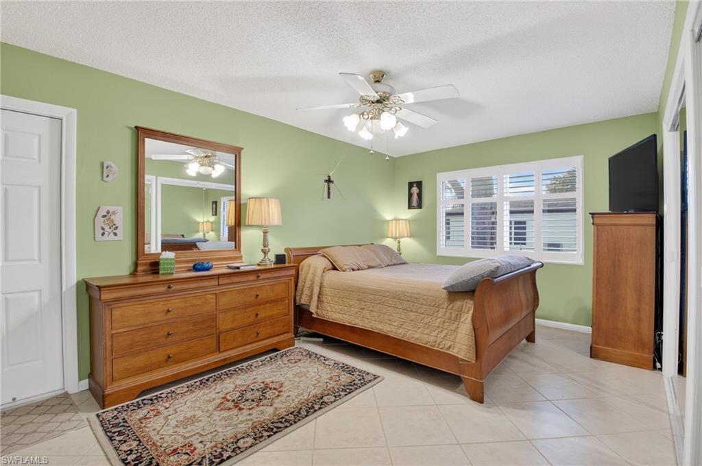 572 High Point Drive, Unit D Delray Beach, FL 33445 - Photo 14 of 21 a bedroom with a large bed and a chandelier