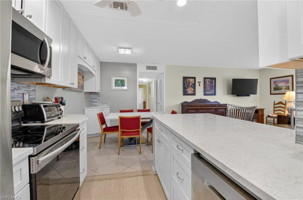 572 High Point Drive, Unit D Delray Beach, FL 33445 - Photo 21 of 21 a kitchen with stainless steel appliances kitchen island granite countertop a sink and cabinets