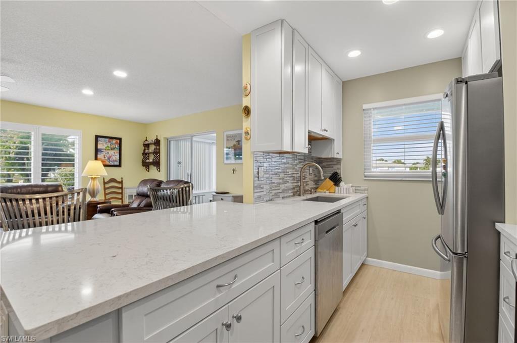 572 High Point Drive, Unit D Delray Beach, FL 33445 - Photo 3 of 21 a kitchen with counter top space cabinets and stainless steel appliances