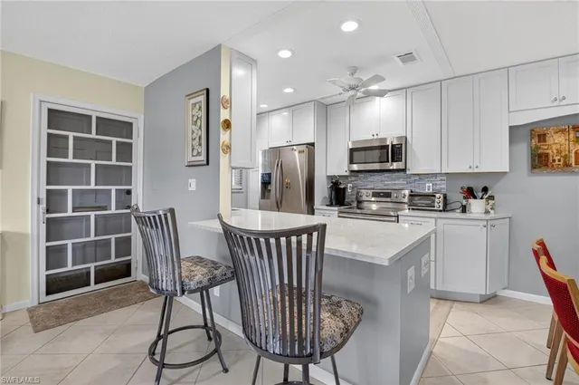 a kitchen with stainless steel appliances kitchen island granite countertop a stove microwave and refrigerator
