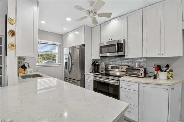 a kitchen with a dining table chairs refrigerator and cabinets
