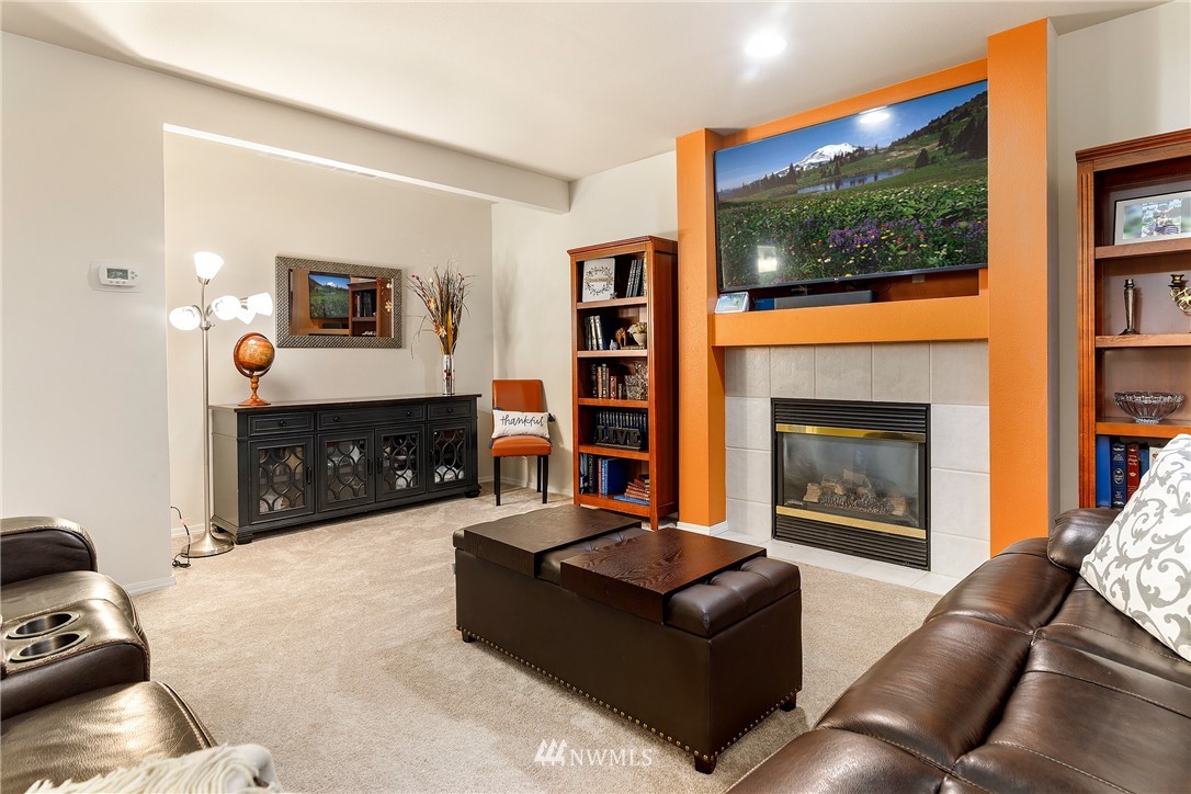 3136 Northeast 20th Place Renton, WA 98056 - Photo 11 of 29 a living room with furniture a fireplace and a flat screen tv