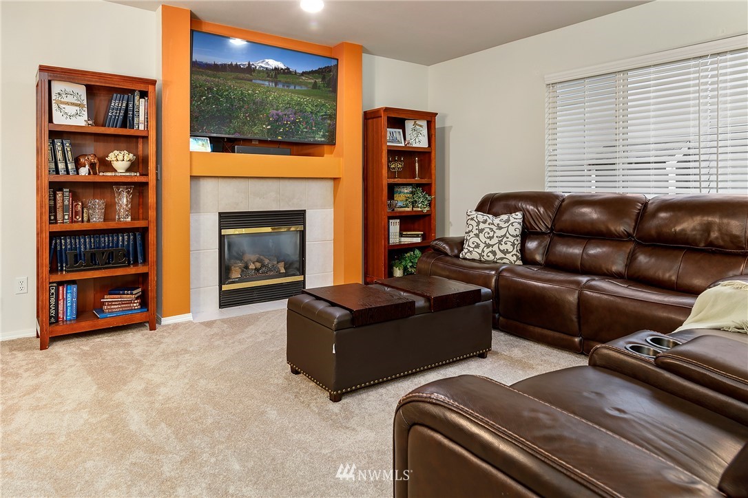 3136 Northeast 20th Place Renton, WA 98056 - Photo 12 of 29 a living room with furniture a flat screen tv and a fireplace