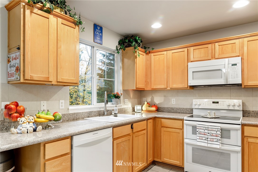 3136 Northeast 20th Place Renton, WA 98056 - Photo 7 of 29 a kitchen with stainless steel appliances white cabinets sink and a window