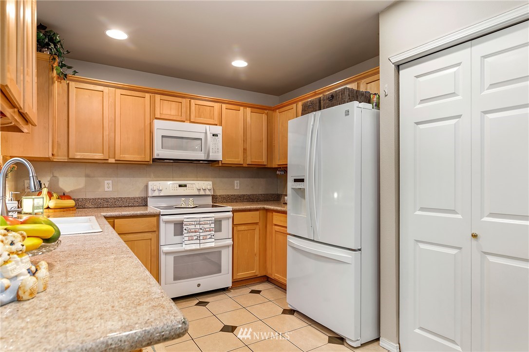 3136 Northeast 20th Place Renton, WA 98056 - Photo 8 of 29 a kitchen with stainless steel appliances granite countertop a refrigerator sink and stove