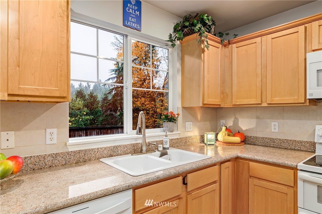 3136 Northeast 20th Place Renton, WA 98056 - Photo 10 of 29 a kitchen with stainless steel appliances granite countertop a sink a granite counter tops and a large window