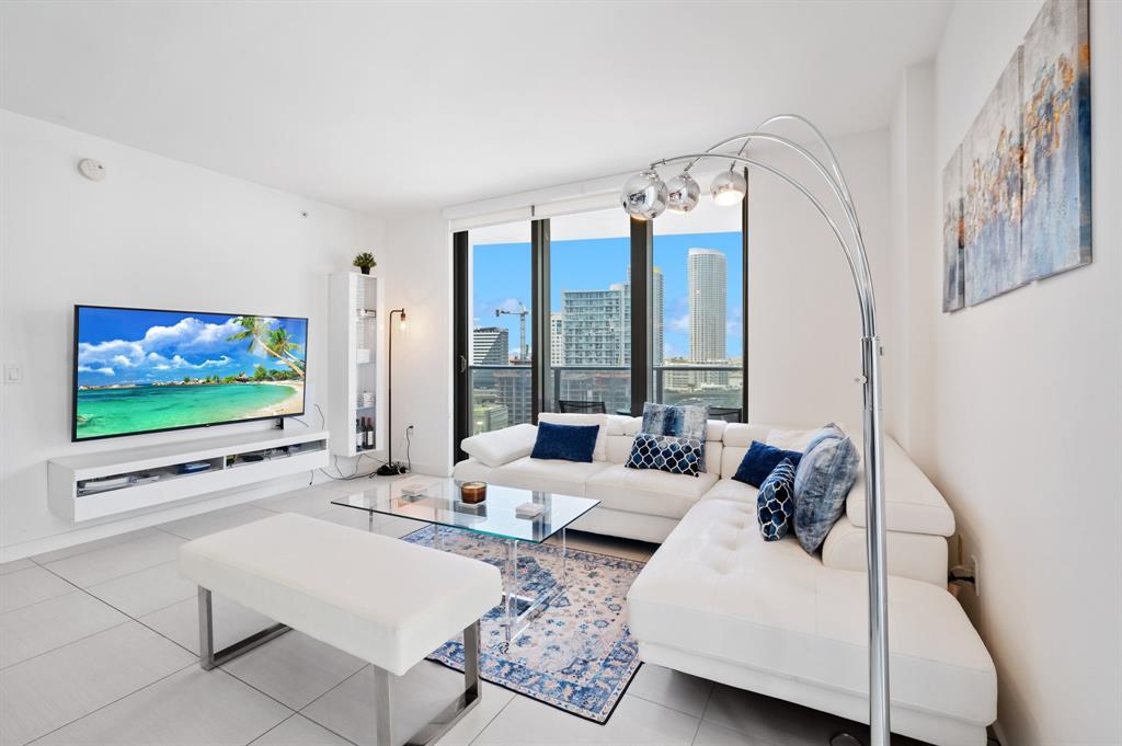 31 Southeast 6th Street, Unit 2002 Miami, FL 33131 - Photo 2 of 24 a living room with furniture and a flat screen tv