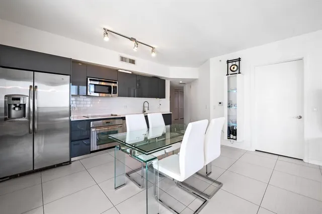 a kitchen with stainless steel appliances kitchen island granite countertop a refrigerator and a stove top oven