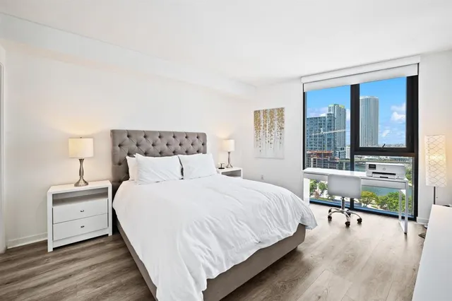 a bedroom with a bed and a large window