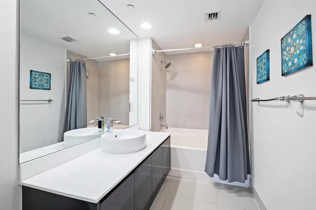 a bathroom with a sink a mirror and a shower