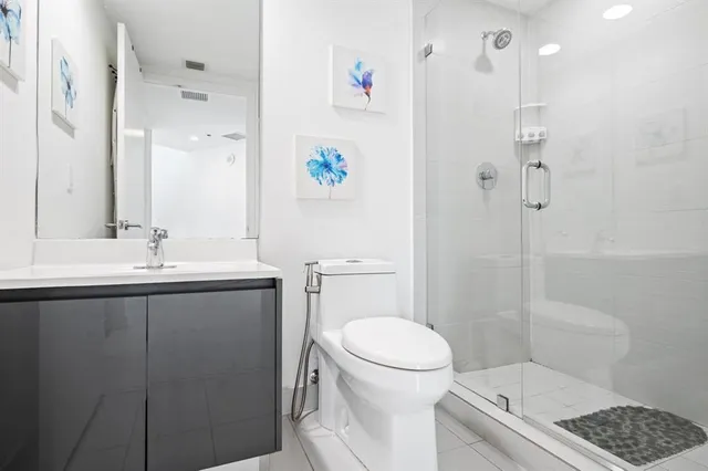 a bathroom with a sink a toilet and shower