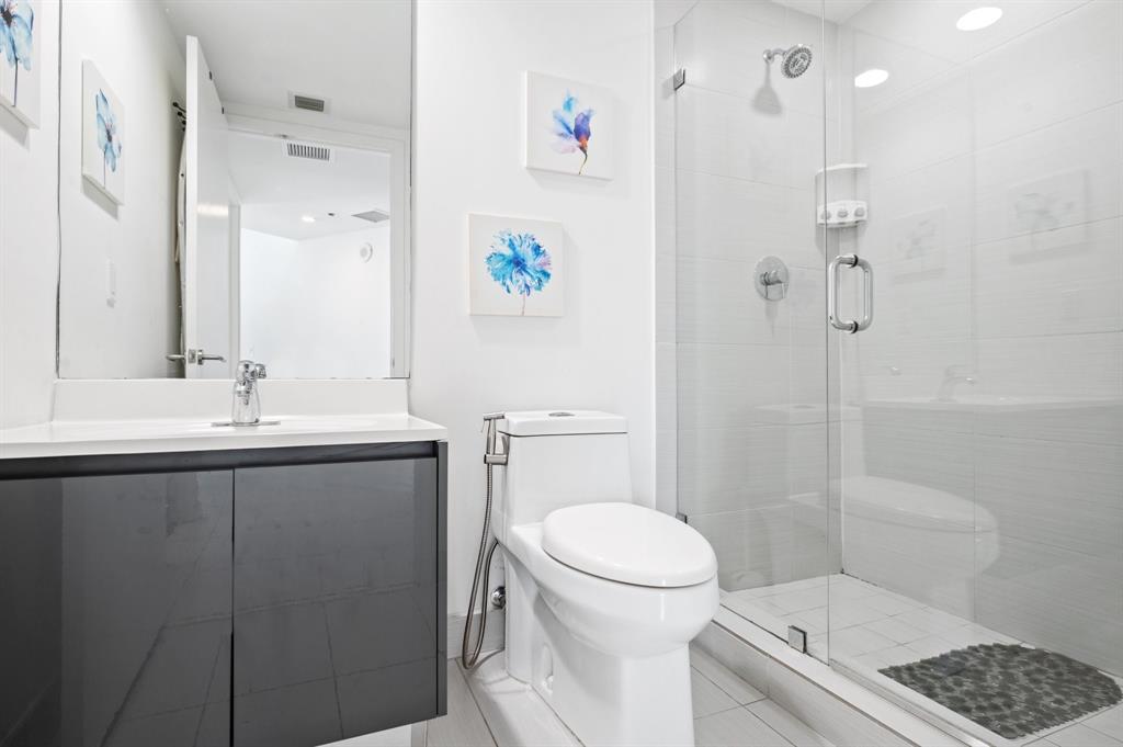 31 Southeast 6th Street, Unit 2002 Miami, FL 33131 - Photo 10 of 24 a bathroom with a sink a toilet and shower