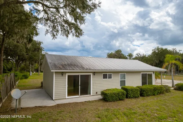 a view of backyard of house and car parked