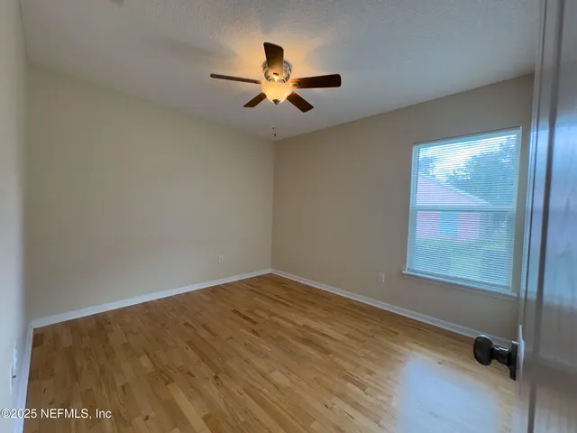wooden floor in an empty room with a window