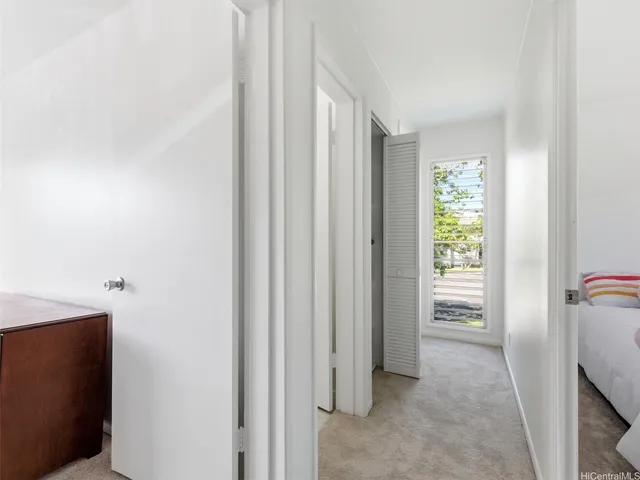 a view of hallway with furniture and a window
