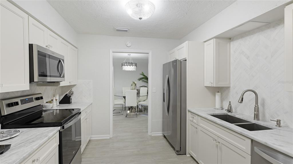 6726 South Lockwood Ridge Road Sarasota, FL 34231 - Photo 17 of 36 a kitchen with a sink stove and refrigerator