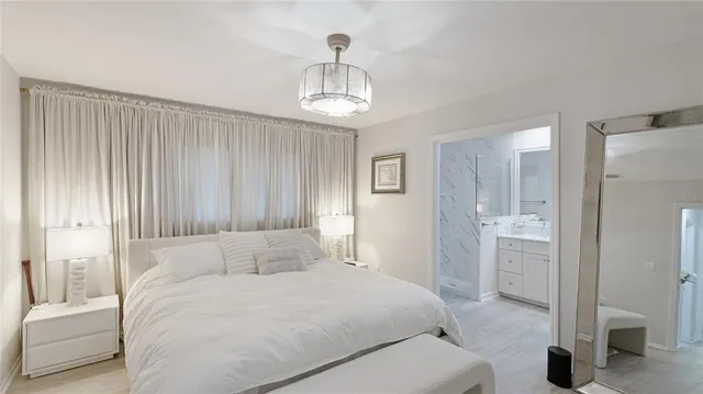a bedroom with a bed and a chandelier