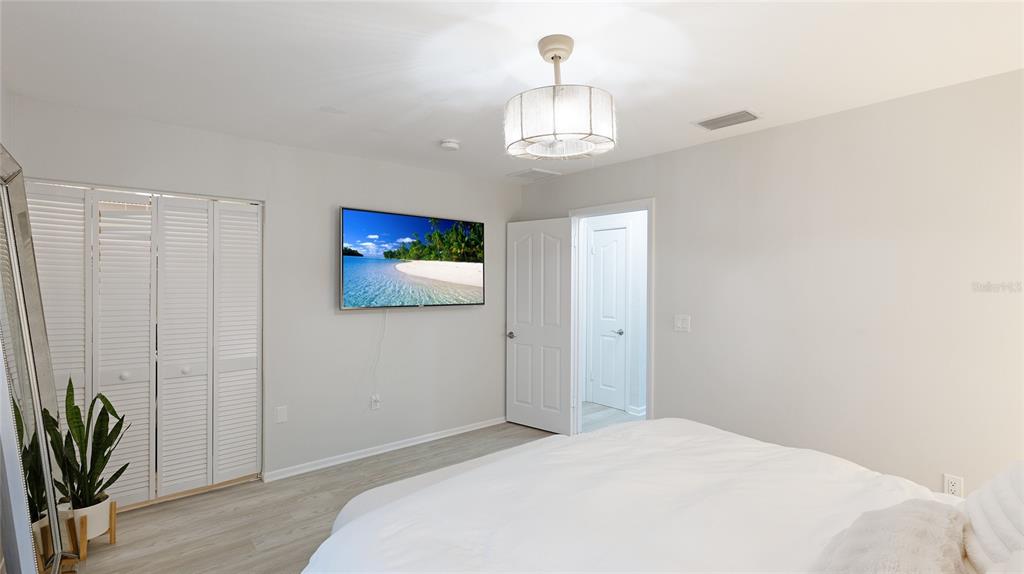 6726 South Lockwood Ridge Road Sarasota, FL 34231 - Photo 20 of 36 a bedroom with a bed and a chandelier