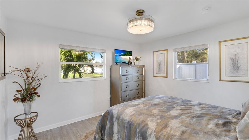 6726 South Lockwood Ridge Road Sarasota, FL 34231 - Photo 22 of 36 a bedroom with a bed and a chandelier