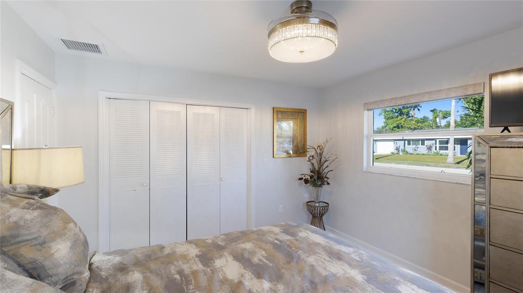 6726 South Lockwood Ridge Road Sarasota, FL 34231 - Photo 23 of 36 a bedroom with a bed and a chandelier