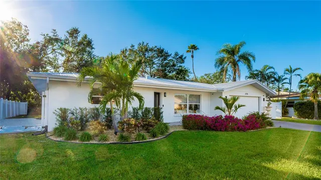 a view of a house with a yard and potted plants