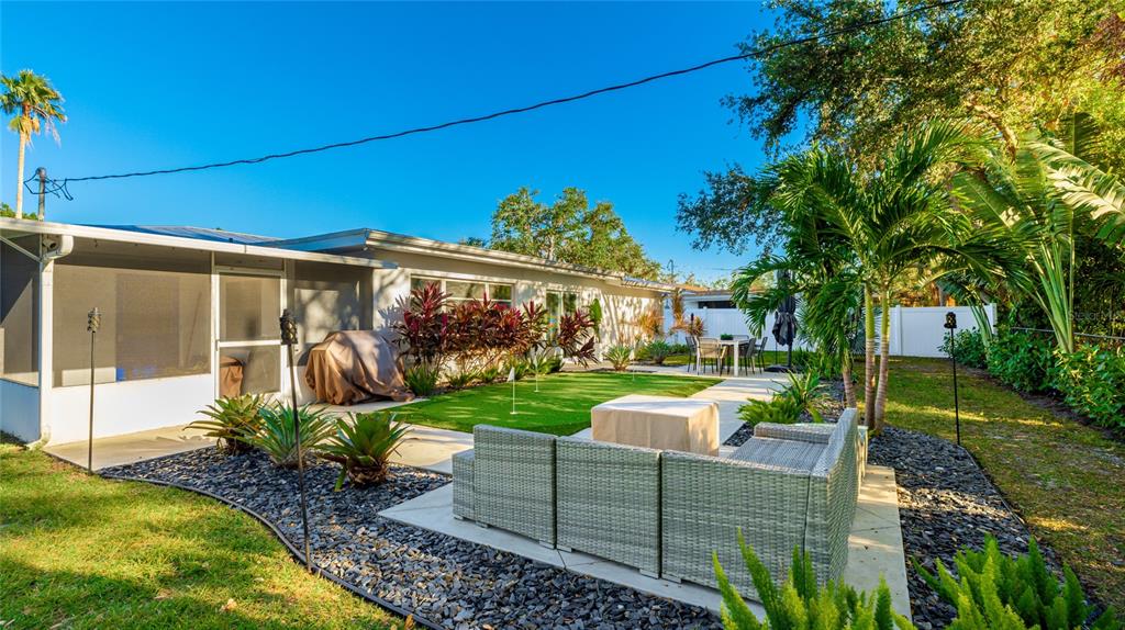 6726 South Lockwood Ridge Road Sarasota, FL 34231 - Photo 31 of 36 a view of a patio with couches chairs potted plants and a big yard