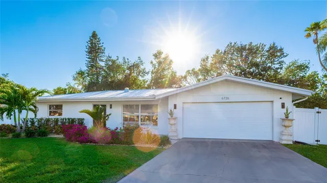 a view of a house with a yard and potted plants