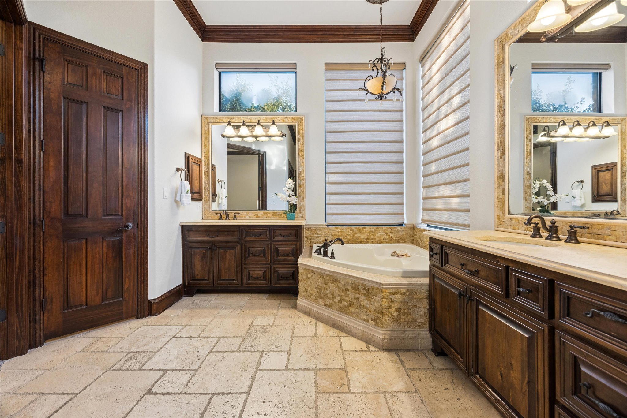 11805 Ranchview Court Austin, TX 78732 - Photo 13 of 36 Bathroom featuring natural stone tile flooring, a corner soaking tub with mosaic tile surround, and dual wood vanities with integrated sinks and stone countertops