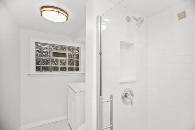 a bathroom with a window and a shower