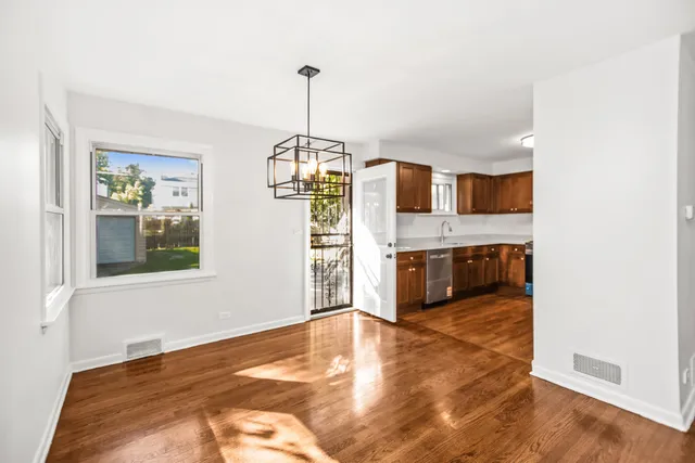 a view of a kitchen with a sink and dishwasher a refrigerator with wooden floor