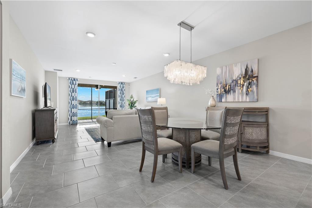 14558 Edgewater Circle Naples, FL 34114 - Photo 10 of 40 a dining room with furniture a chandelier and kitchen view