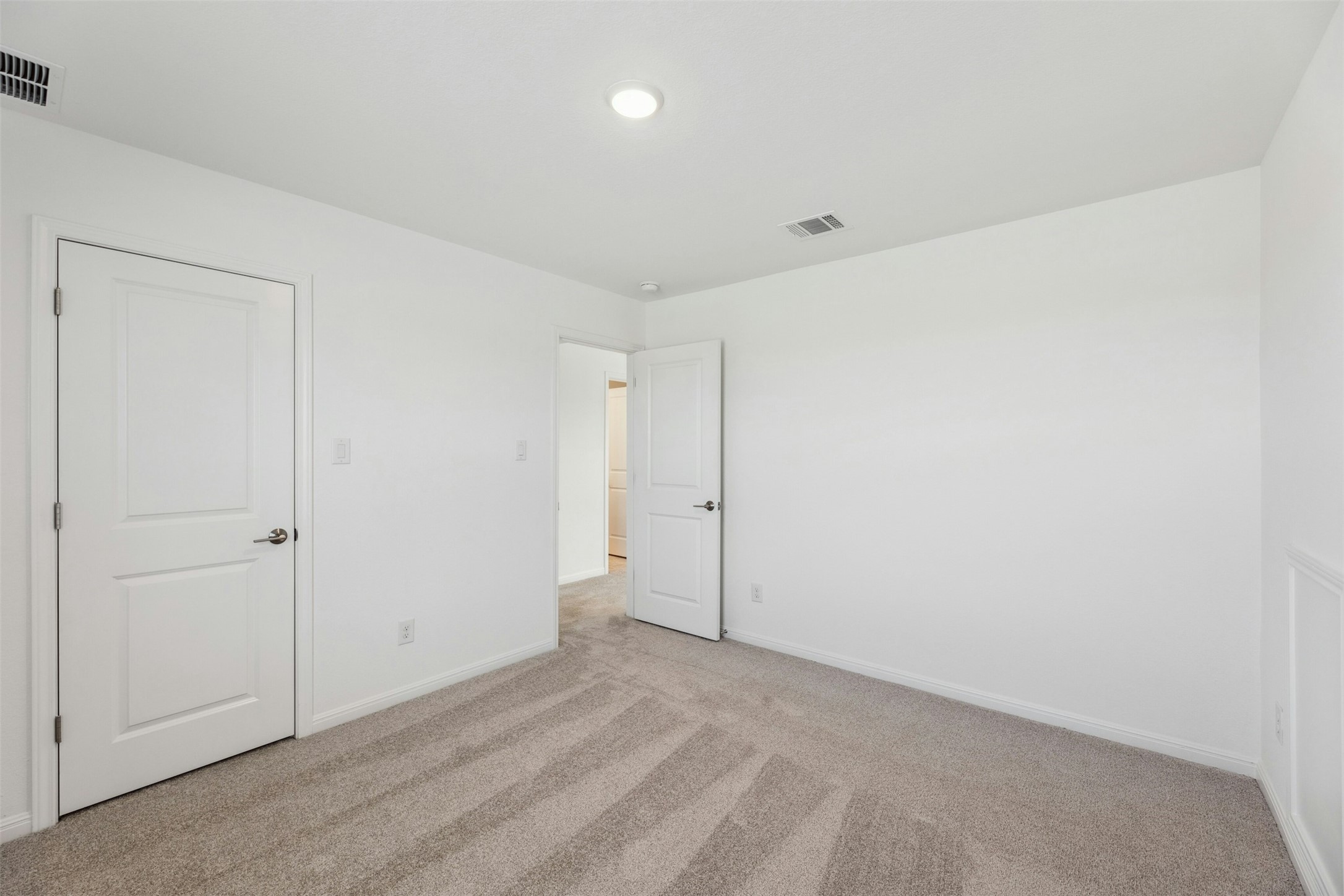 2001 Wynn Road Hutto, TX 78634 - Photo 31 of 39 A well-lit bedroom with fresh, neutral carpet provides a serene and adaptable living space.