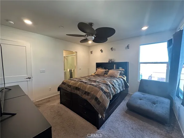 a bedroom with a bed a chandelier and a window