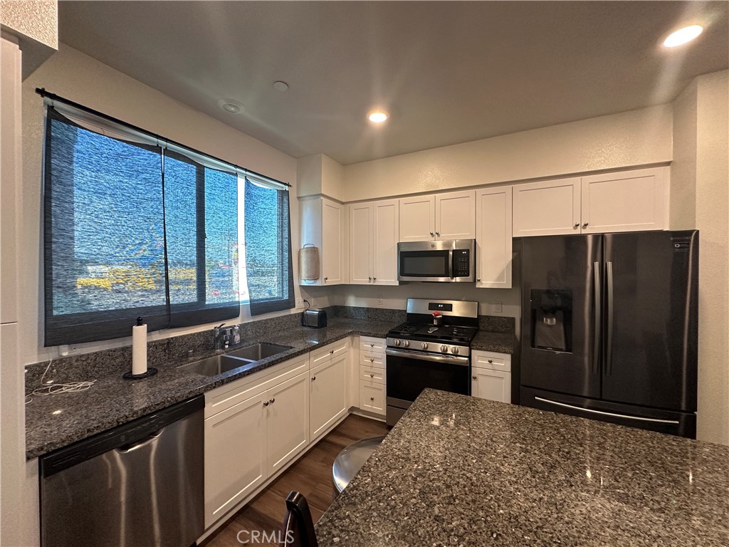17612 Garden House Lane Bellflower, CA 90706 - Photo 17 of 31 a kitchen with stainless steel appliances granite countertop a sink stove and refrigerator