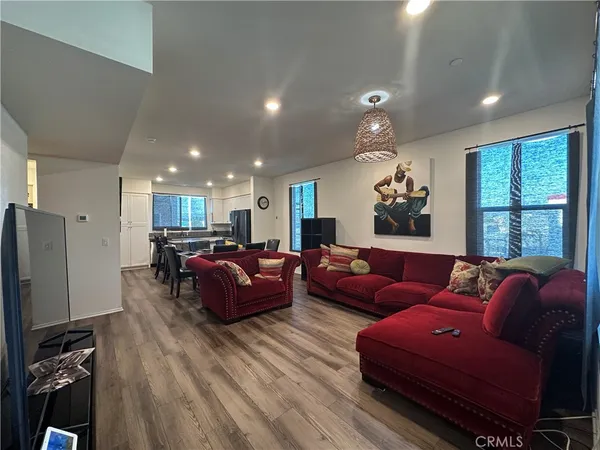 a living room with furniture a large window and wood floor