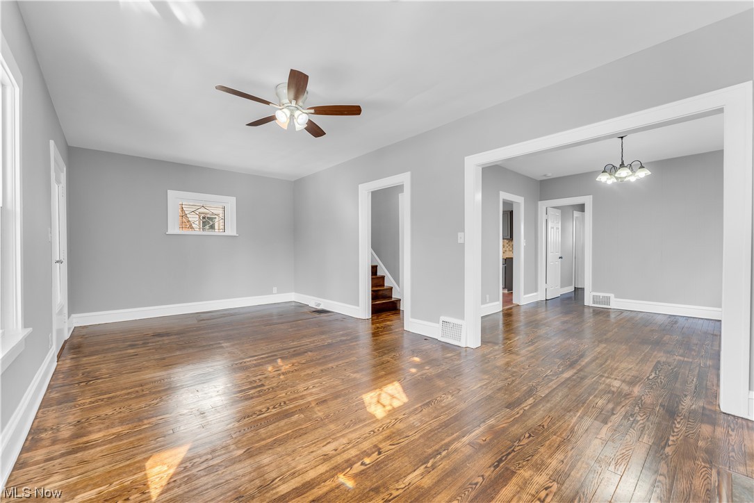 3557 Ludgate Road Cleveland, OH 44120 - Photo 4 of 32 Unfurnished room featuring ceiling fan with notable chandelier and dark wood-type flooring