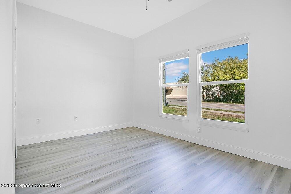 2498 Mitchell Avenue Mims, FL 32754 - Photo 15 of 31 a view of an empty room with wooden floor and a window