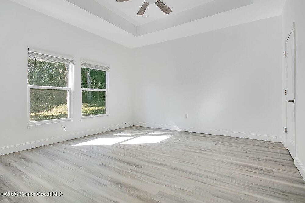 2498 Mitchell Avenue Mims, FL 32754 - Photo 18 of 31 an empty room with wooden floor and windows