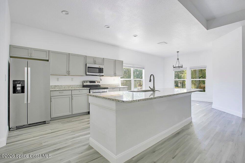 2498 Mitchell Avenue Mims, FL 32754 - Photo 8 of 31 a kitchen with granite countertop a refrigerator stove top oven and sink