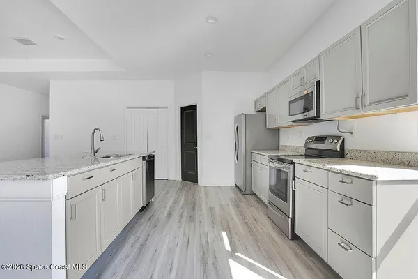 a kitchen with cabinets a sink and appliances