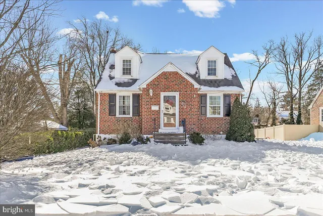 a front view of a house with a yard covered in snow