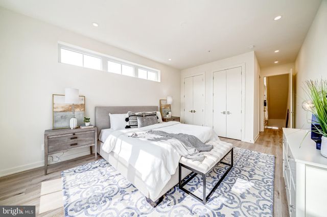 a spacious bedroom with a bed and wooden floor